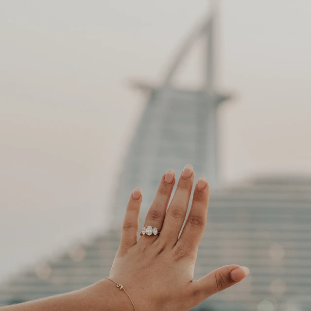 Fotograf für Heiratsanträge Dubai Ein Paar, das während seines Heiratsantrags am Strand beim Burj Al Arab in Dubai von einem Fotografen festgehalten wird.