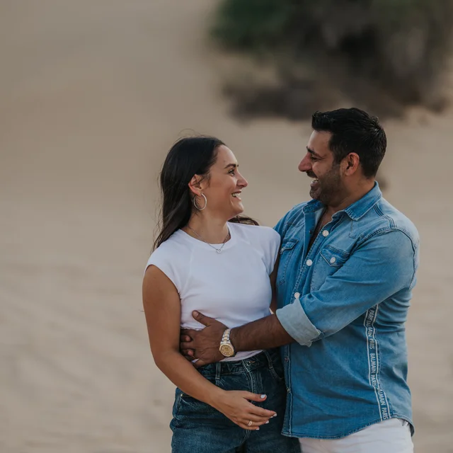 A couple looking at eachother being photographed by a Dubai Photographer in the desert. Dubai Photographer