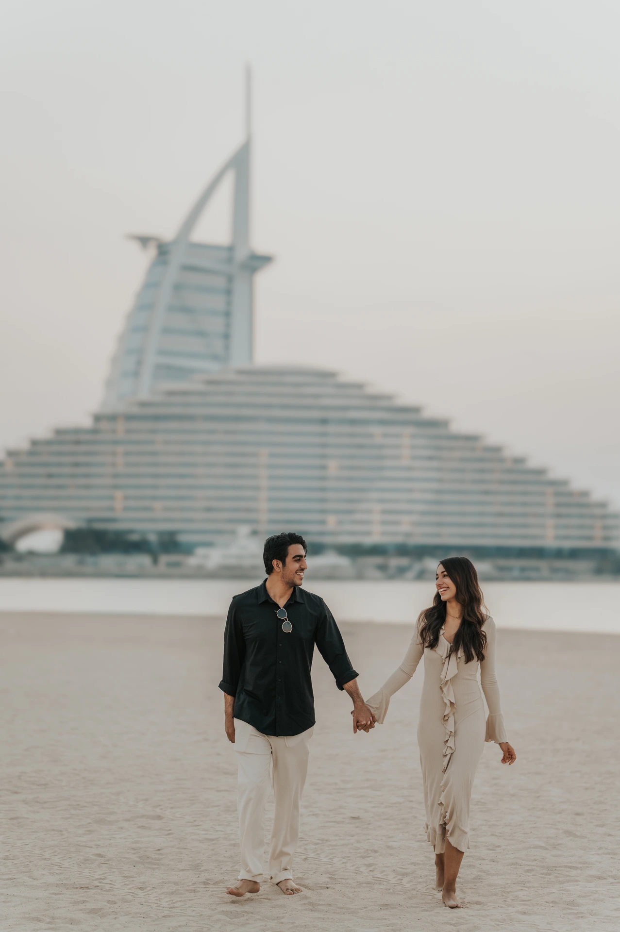 Couple walking hand in hand after their proposal with a picnic