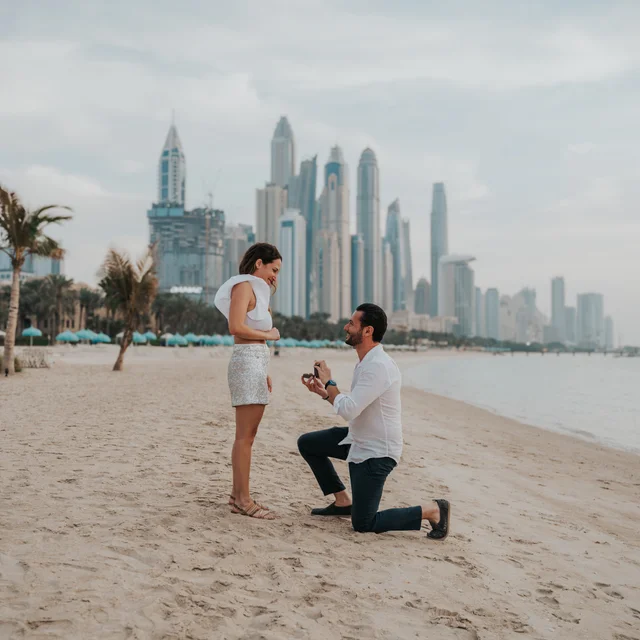 Dubai proposal photographer A couple being photographed with Dubai Marina in the background while the guy proposes to his girlfriend.