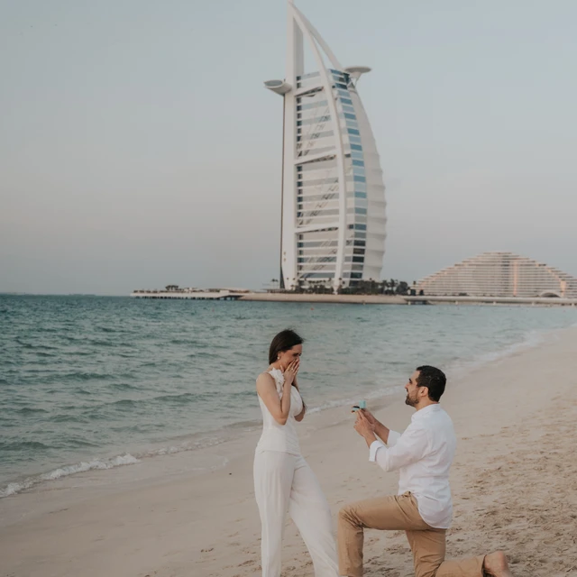 Dubai Proposal Photographer Couple being photographed by a Dubai proposal photographer while they are in front of the Burj Al Arab in Dubai.