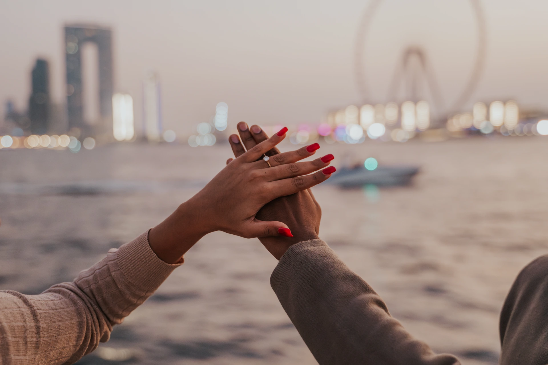 A proposal on a yacht in Dubai with Dubai Marina and Blue Waters in the background.