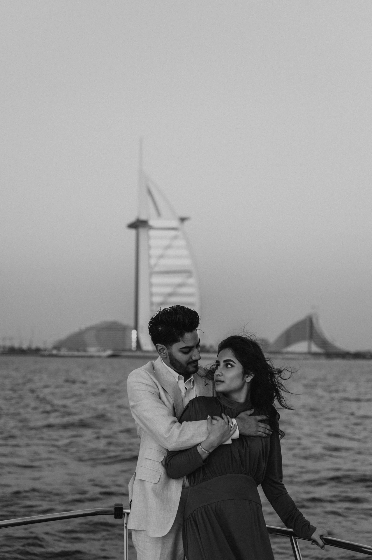 A proposal on a yacht in Dubai with Dubai Marina and Blue Waters in the background.