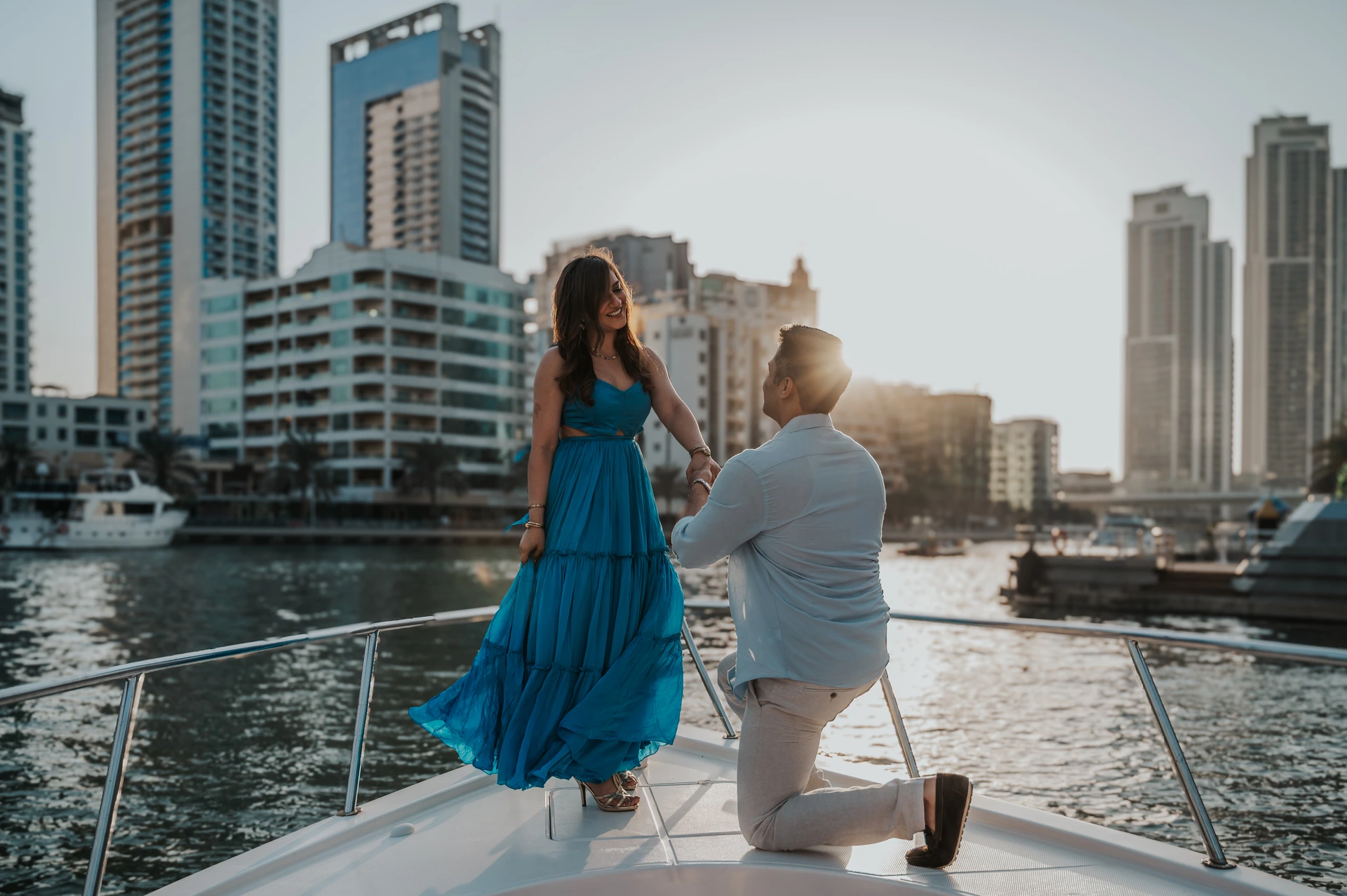 A proposal on a yacht in Dubai with Dubai Marina and Blue Waters in the background.