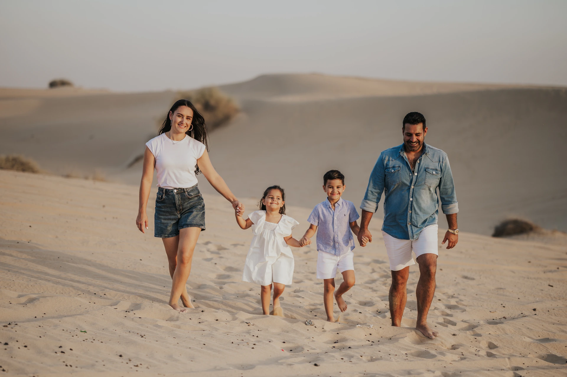Family walking together on Dubai desert dunes