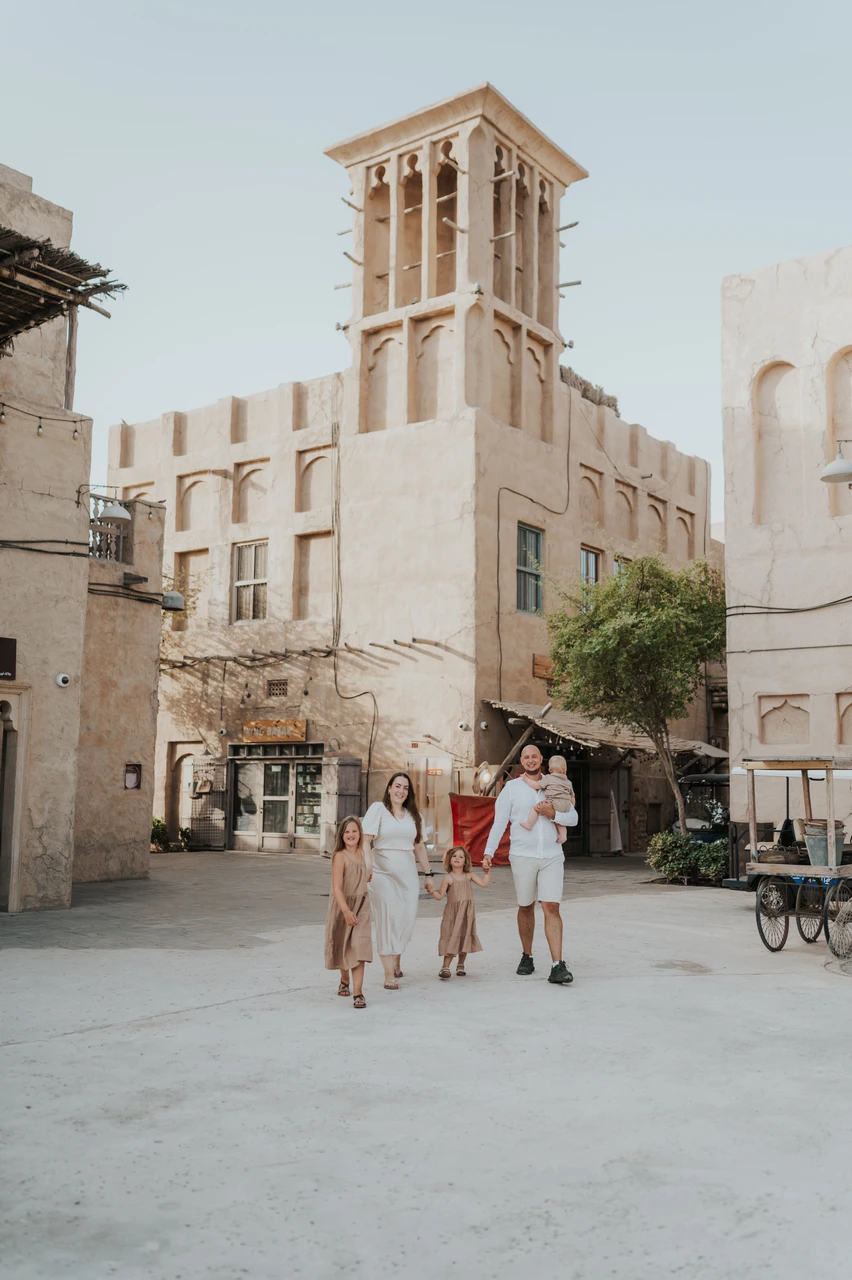 Family photoshoot in Old Dubai - heritage street walk A family walks through a historic Old Dubai street lined with traditional architecture during a lifestyle family photoshoot.