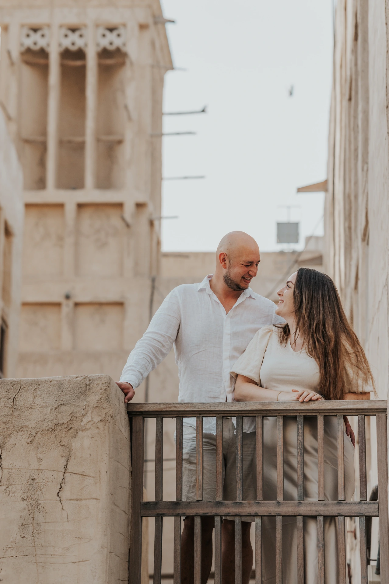 Parents smile at each other in an Old Dubai lane during a warm family photoshoot portrait.