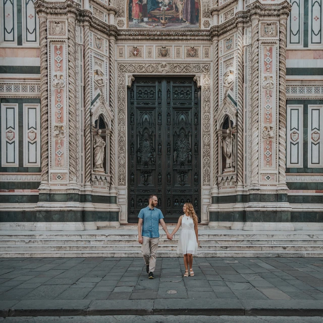 Florence couple photoshoot framed by the Duomo doorway A square photograph shows the couple beneath the Duomo’s decorated doorway during their Florence couple photoshoot.