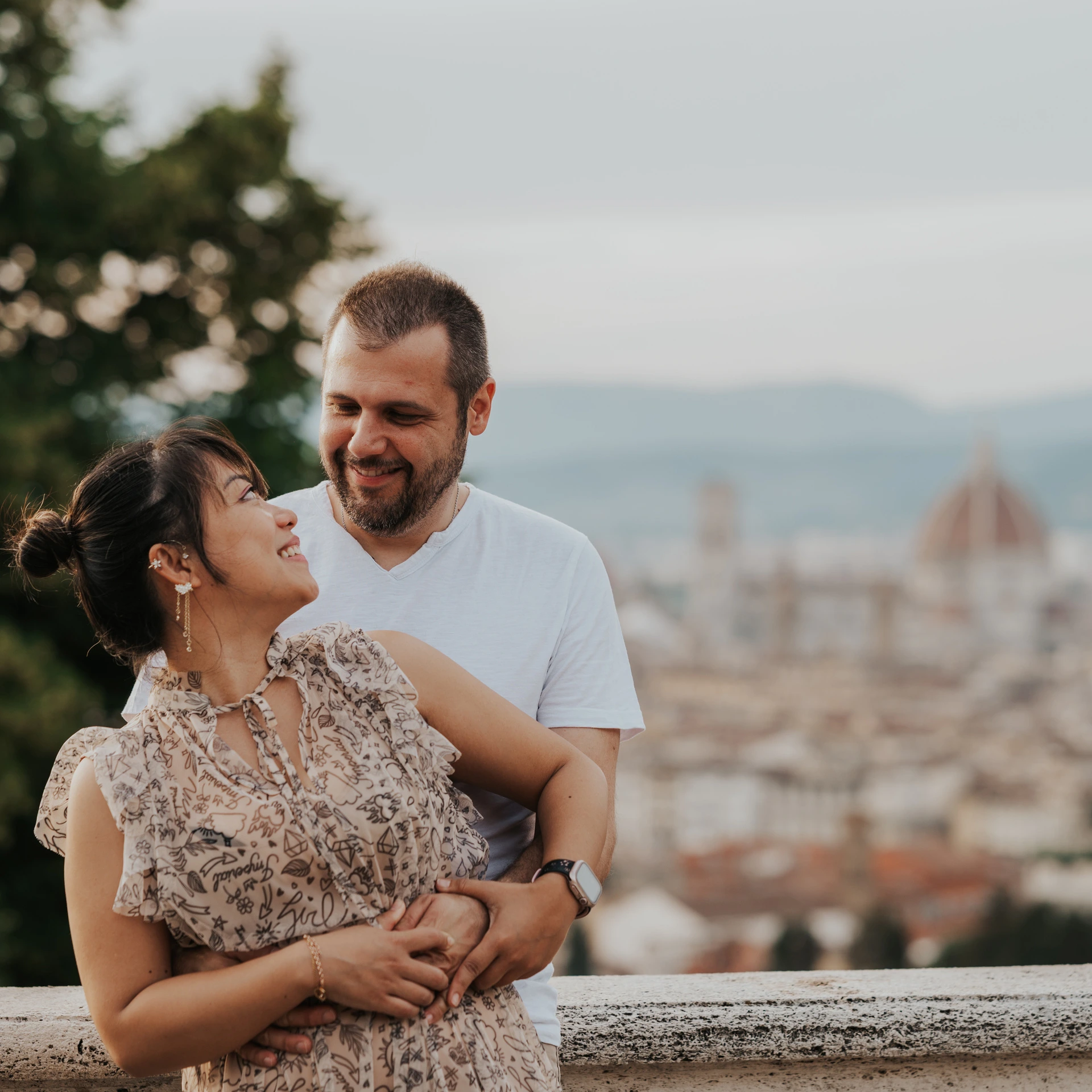 The couple smile at one another in a close embrace during their Florence photoshoot, with the Duomo softly blurred behind them.