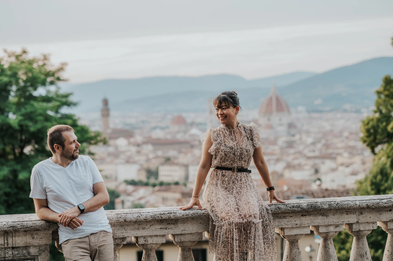 Florence couple photoshoot at the balustrade edge The man leans against the balustrade beside the woman during their Florence photoshoot, with the Duomo behind them.