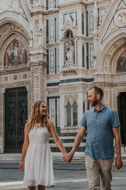 Florence couple photoshoot around the cathedral’s marble corner The couple walk together beside the Duomo’s patterned marble exterior during their Florence photoshoot.