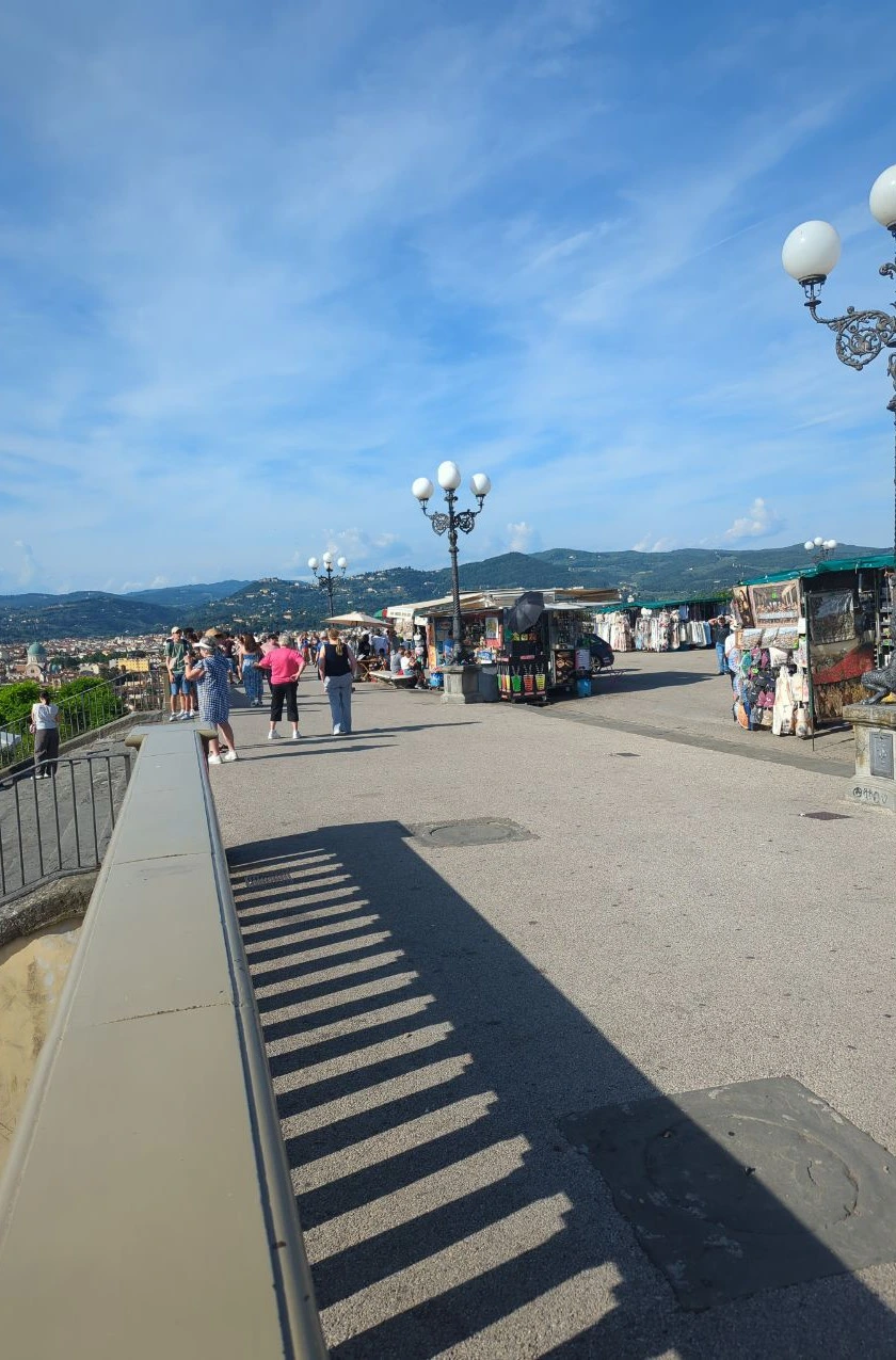 Florence Photoshoot Timing - Piazzale Michelangelo Visitors gather beside railings and souvenir stalls at Piazzale Michelangelo, showing the shared public setting of a Florence photoshoot viewpoint.