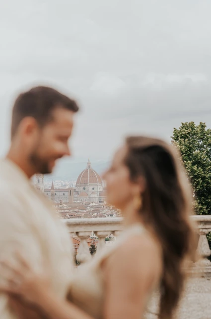Florence proposal photoshoot with the Duomo between the couple The Duomo appears between the softly blurred couple in a close portrait during their Florence proposal photoshoot.