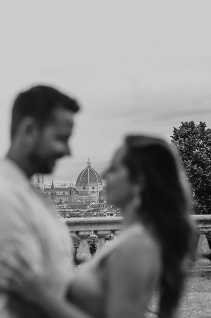 A black-and-white Duomo view in a Florence proposal photoshoot Black-and-white photograph with Florence’s Duomo in focus between the softly blurred couple during their proposal photoshoot.
