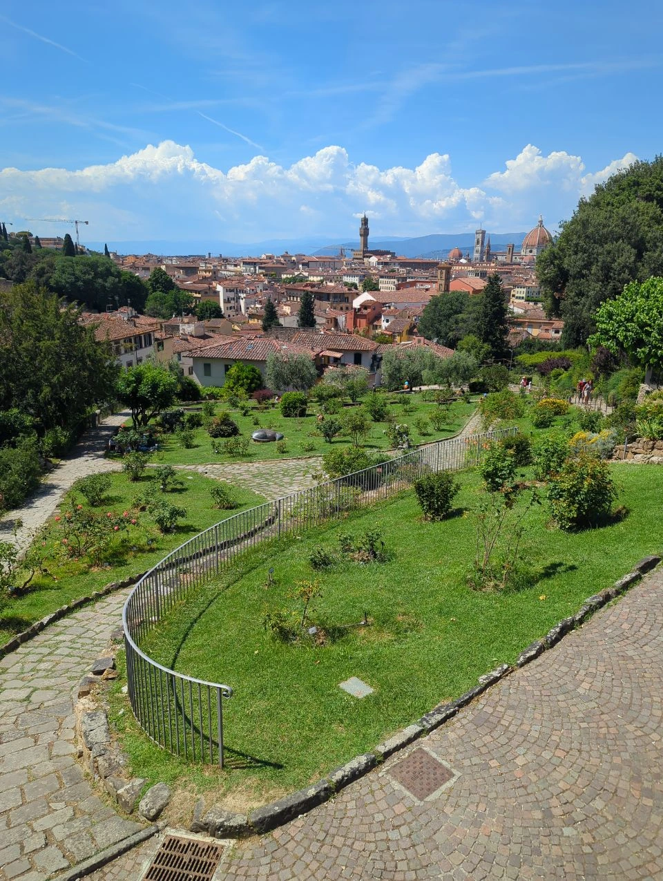 Florence Rose Garden and Skyline Paths and lawns in Florence’s Rose Garden overlook terracotta rooftops and the Duomo beneath a blue sky.