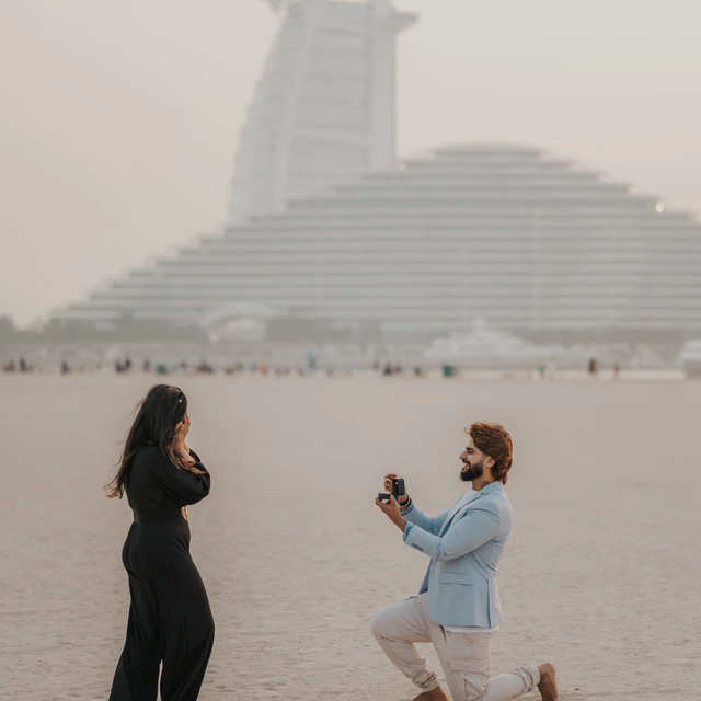 Fotografo Pedida de mano en Dubai Una pareja fotografiada por un fotógrafo en Dubái durante su propuesta de matrimonio, en la playa junto al Burj Al Arab.