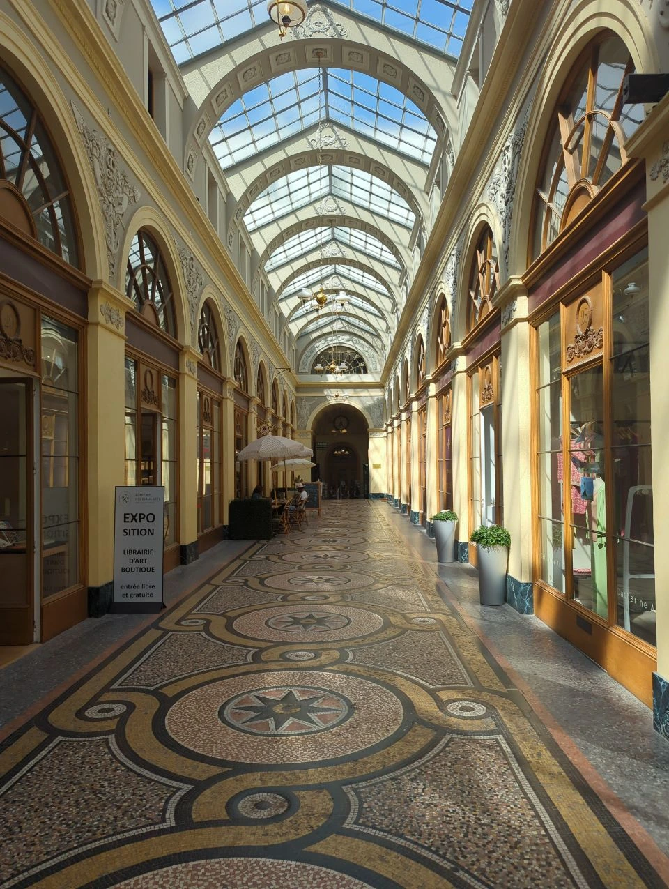 Paris Photoshoot - Galerie Vivienne Symmetry Galerie Vivienne's patterned mosaic floor leads through symmetrical shopfronts and glass-roofed arches, creating an architectural setting for a Paris photoshoot.
