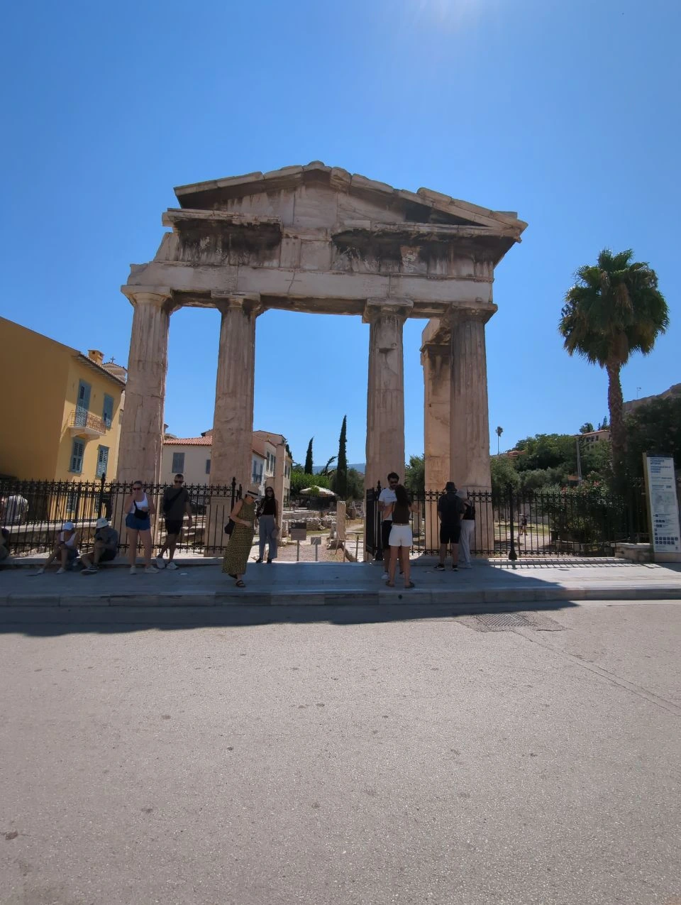 Gate of Athena Archegetis in Athens The Gate of Athena Archegetis stands behind a street and fence in central Athens, with visitors gathered beneath its columns.