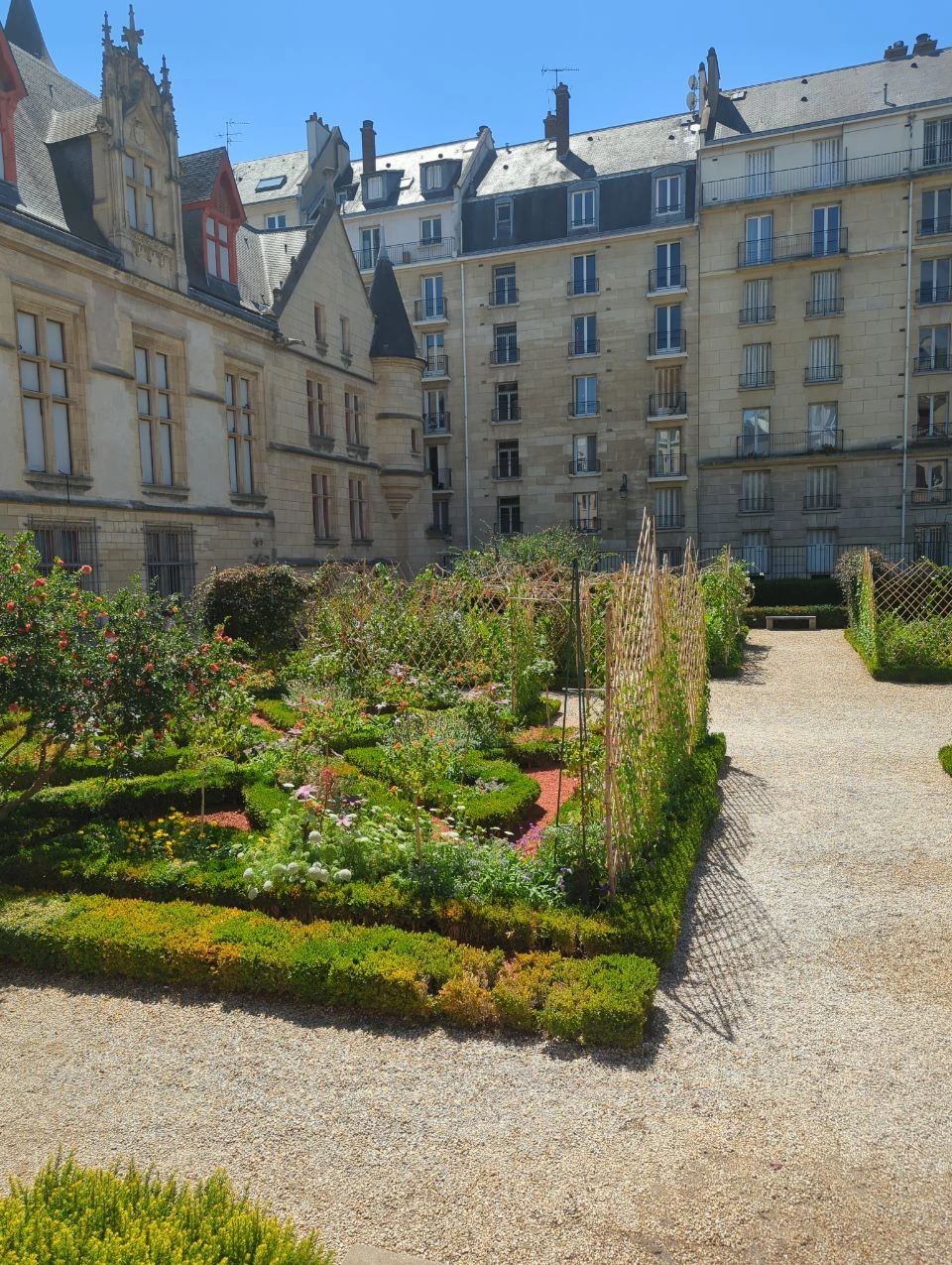 Paris Photoshoot - Hôtel de Sens Garden Formal hedges, flower beds and gravel paths sit beside the historic Hôtel de Sens in Paris, creating a layered garden setting for a photoshoot.