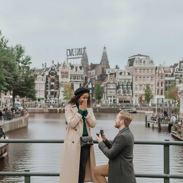 Huwelijksaanzoek fotograaf Amsterdam Huwelijksaanzoek op een brug in Amsterdam vastgelegd door een huwelijksaanzoek fotograaf met grachten op de achtergrond