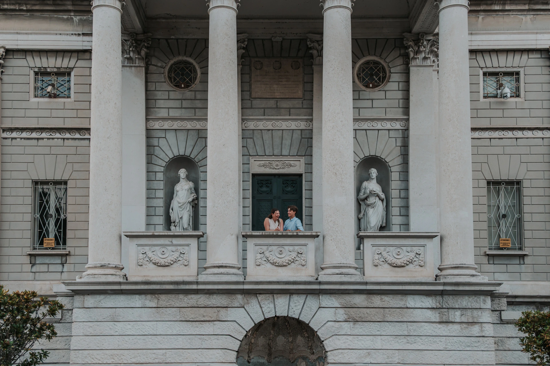 Wide view of Tempio Voltiano’s columns and carved stone balcony with the couple during their Lake Como couple photoshoot.
