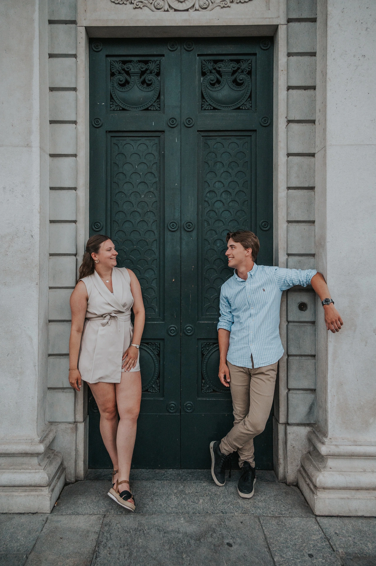 Couple beside the green door and stone columns of Tempio Voltiano during their Lake Como couple photoshoot.
