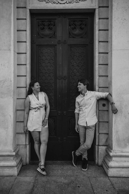 Lake Como couple photoshoot by the museum door in black and white Black-and-white photograph of the couple by Tempio Voltiano’s green door during their Lake Como couple photoshoot.