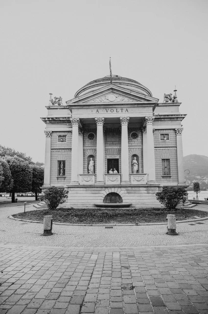 Lake Como couple photoshoot at Tempio Voltiano in black and white Black-and-white view of the couple beneath the columns of Tempio Voltiano during their Lake Como couple photoshoot.