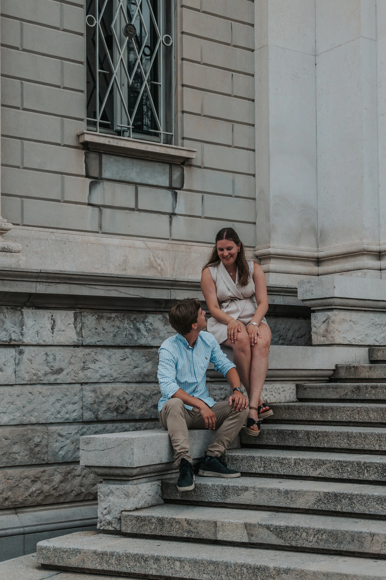 Closer portrait of the couple sitting together on the stone steps at Tempio Voltiano during their Lake Como couple photoshoot.