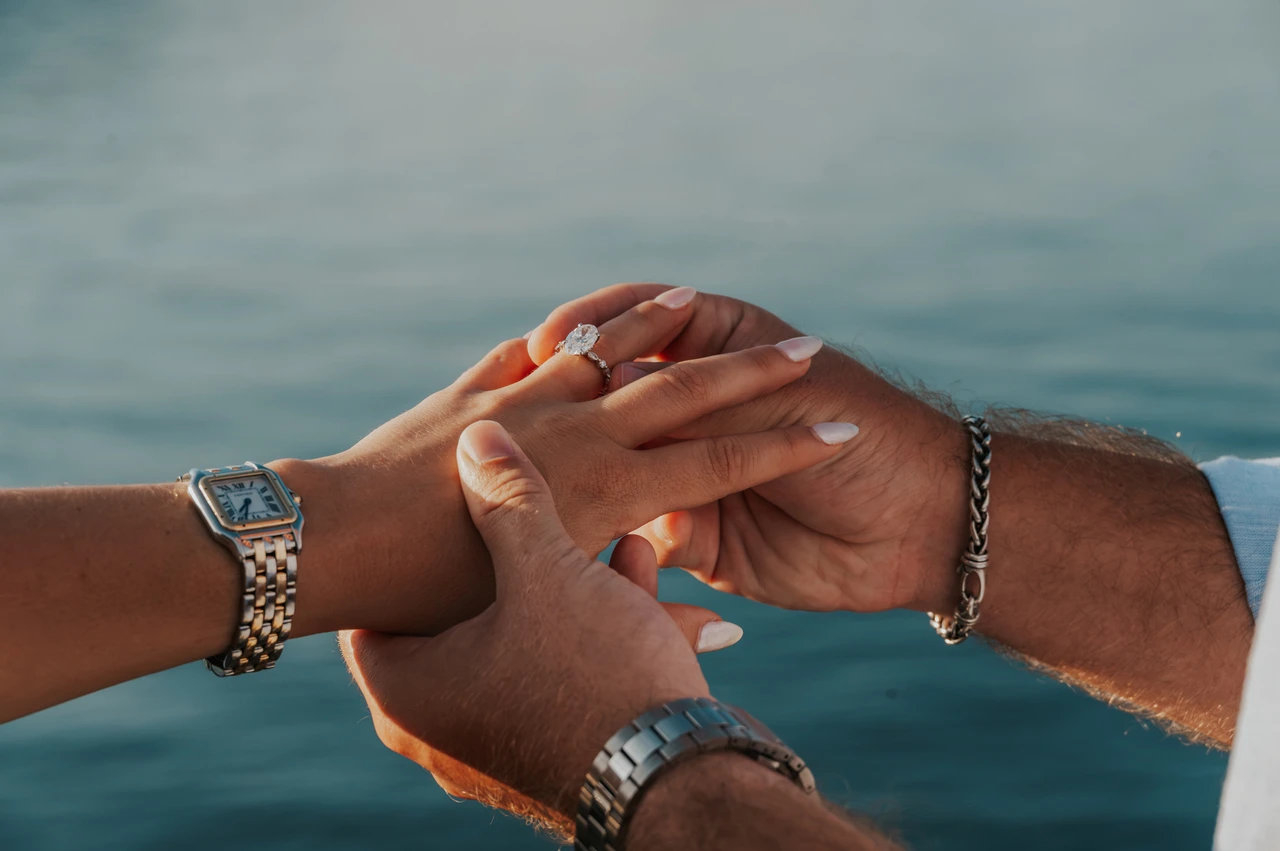 Lake Como photoshoot detail of the engagement ring and joined hands A close view of the woman’s engagement ring as the couple hold hands above the water during their Lake Como photoshoot in Menaggio.