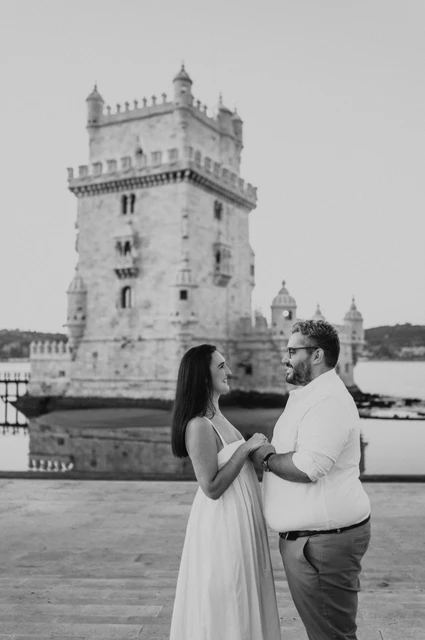 Facing each other in black and white | Lisbon anniversary photoshoot A black-and-white portrait of the couple facing each other with their hands joined by Belém Tower during their anniversary photoshoot in Lisbon.