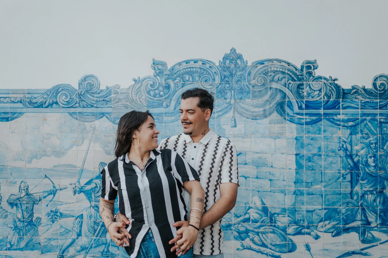A close portrait of the parents together | Lisbon family photoshoot The parents smiling at each other in a close embrace against the blue tile panel during their family photoshoot in Lisbon.