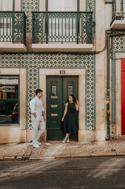 A portrait at the green tiled doorway | Lisbon couple photoshoot The couple standing apart beside a green door surrounded by patterned tiles during their couple photoshoot in Lisbon.