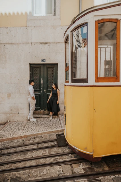 A portrait beside the yellow funicular | Lisbon couple photoshoot The couple standing close by a doorway with a yellow funicular in the foreground during their couple photoshoot in Lisbon.