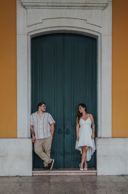 Together beside the green doorway | Lisbon couple photoshoot A closer full-length portrait of the couple leaning on either side of the green door during their couple photoshoot in Lisbon.