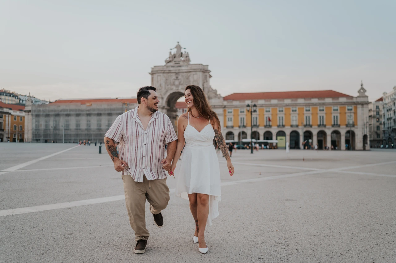 Playful steps across the square | Lisbon couple photoshoot The couple taking lively steps together across Praça do Comércio during their couple photoshoot in Lisbon.