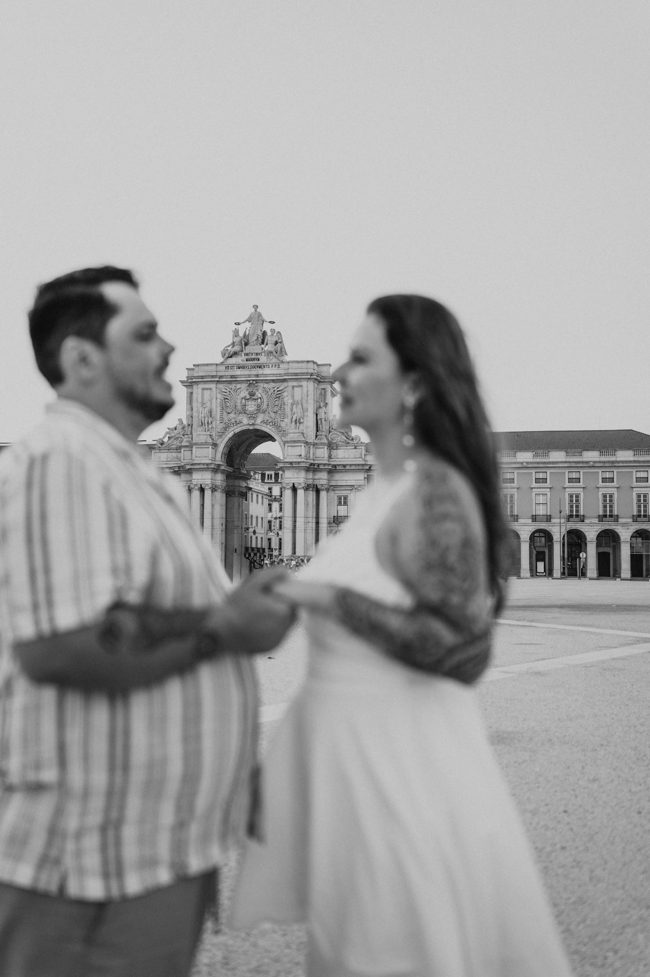 A softly focused black-and-white portrait of the couple with the arch behind them during their couple photoshoot in Lisbon.