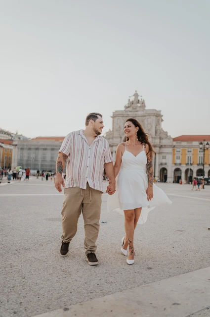A shared glance in Praça do Comércio | Lisbon couple photoshoot The couple sharing a glance as they walk across Praça do Comércio during their couple photoshoot in Lisbon.