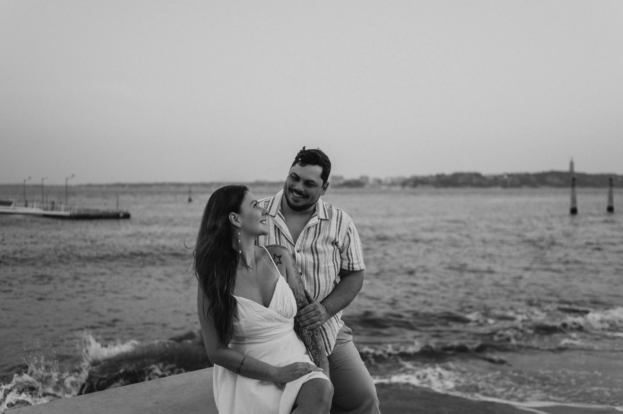 A waterfront portrait in black and white | Lisbon couple photoshoot A black-and-white portrait of the couple together beside the waterfront wall during their couple photoshoot in Lisbon.