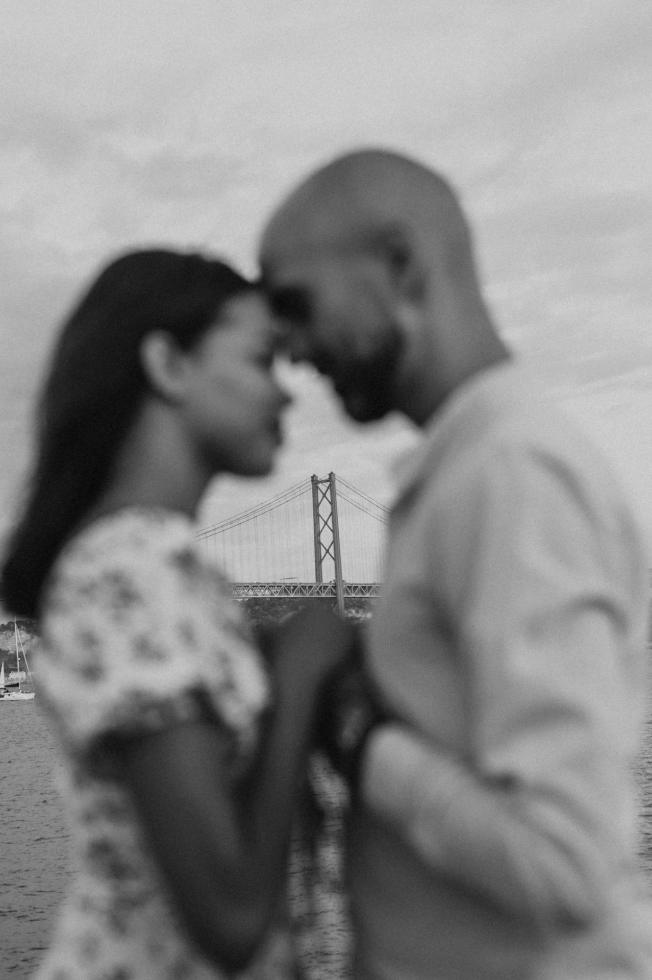 A softly focused black-and-white portrait of the couple with their foreheads together by the river during their couple photoshoot in Lisbon.
