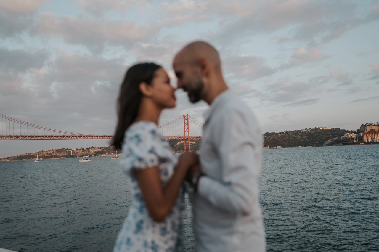 A soft-focus kiss by the river | Lisbon couple photoshoot A softly focused photograph of the couple sharing a kiss beside the river during their couple photoshoot in Lisbon.