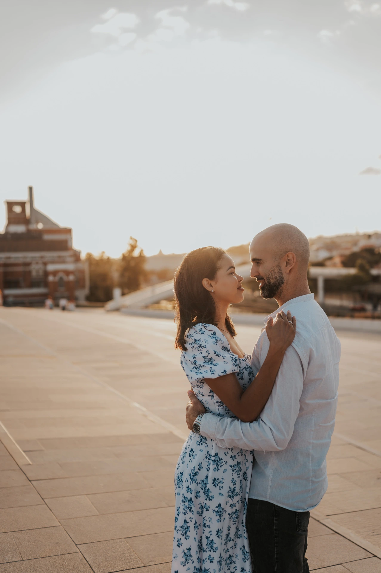 The couple embracing in the warm evening light on the MAAT plaza during their couple photoshoot in Lisbon.