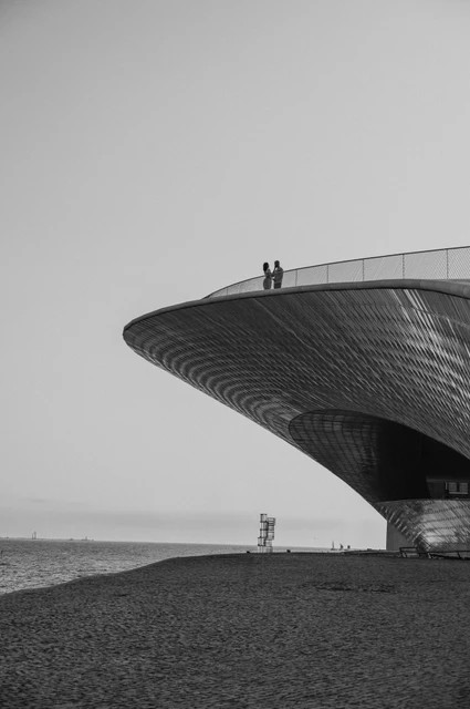 The MAAT roof in black and white | Lisbon couple photoshoot A black-and-white view of the couple standing on the curved MAAT roof during their couple photoshoot in Lisbon.