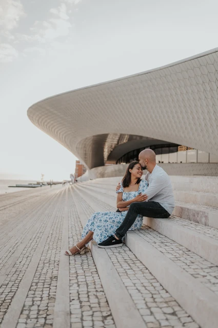 A forehead kiss on the MAAT steps | Lisbon couple photoshoot A forehead kiss while the couple sit on the steps outside the MAAT during their couple photoshoot in Lisbon.