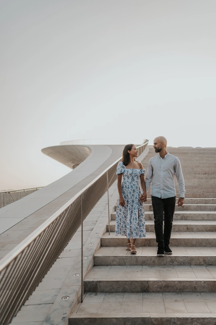 A floral dress in motion on the steps | Lisbon couple photoshoot The woman’s floral dress moving as the couple walk down the MAAT staircase during their couple photoshoot in Lisbon.