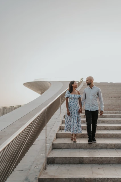 A floral dress in motion on the steps | Lisbon couple photoshoot The woman’s floral dress moving as the couple walk down the MAAT staircase during their couple photoshoot in Lisbon.