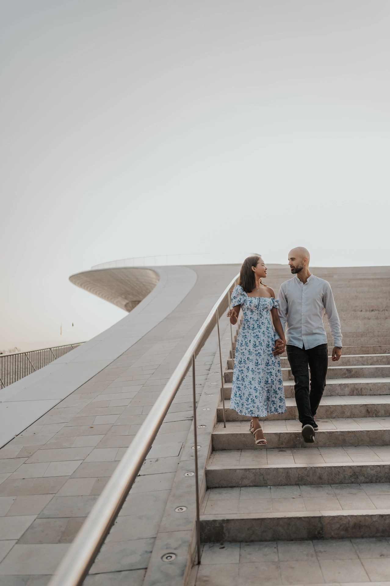 The couple sharing a glance while descending the MAAT steps during their couple photoshoot in Lisbon.