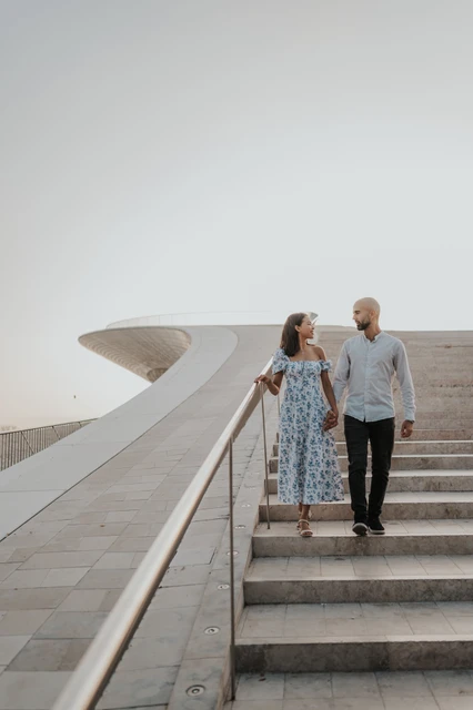 Hand in hand down the MAAT steps | Lisbon couple photoshoot The couple walking down the MAAT staircase hand in hand during their couple photoshoot in Lisbon.
