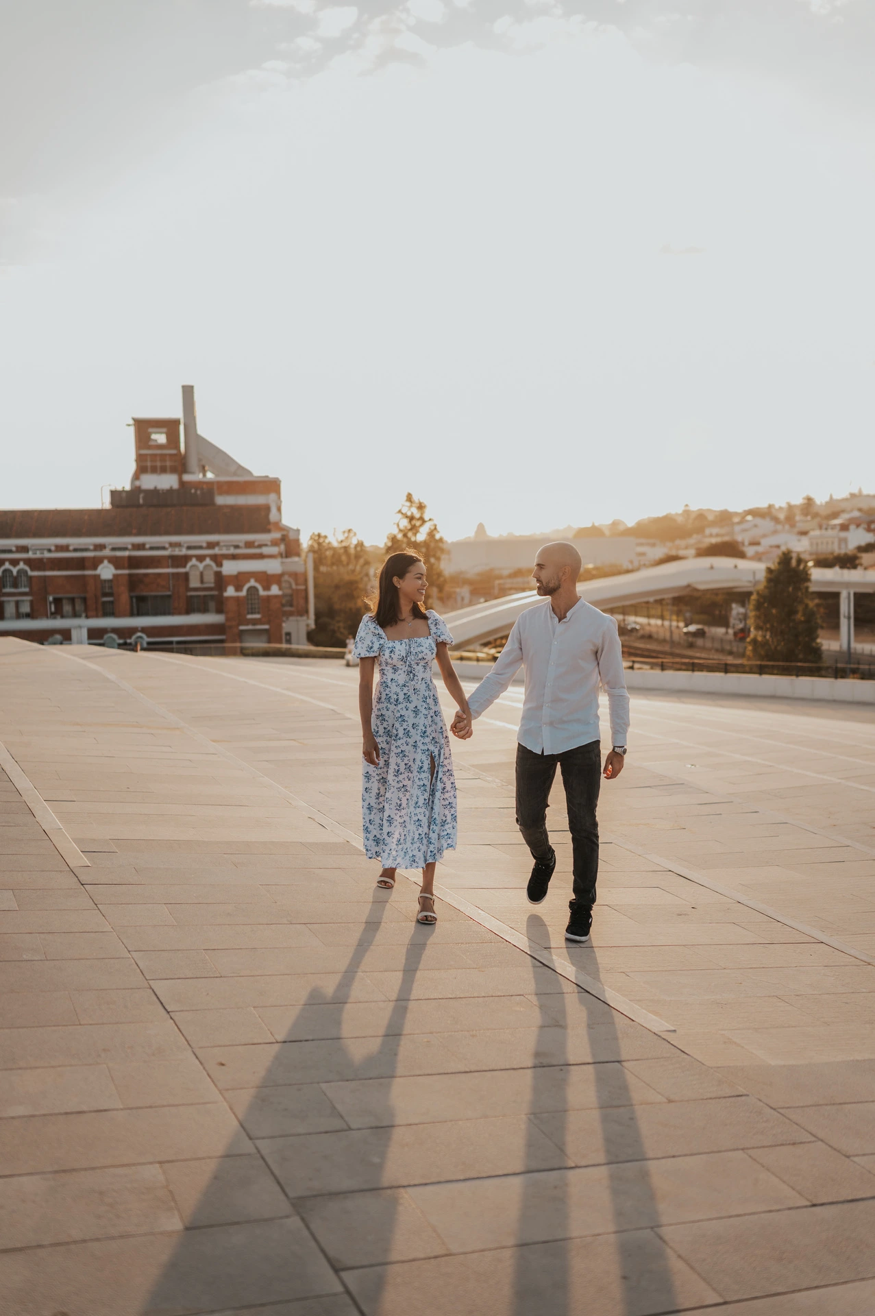 The couple walking towards the camera in the low evening light at the MAAT during their couple photoshoot in Lisbon.