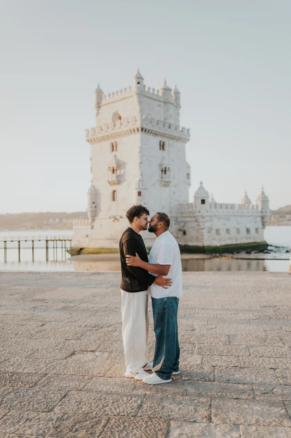 Face to face on the waterfront | Lisbon couple photoshoot The couple standing face to face and leaning close together in front of Belém Tower during their couple photoshoot in Lisbon.